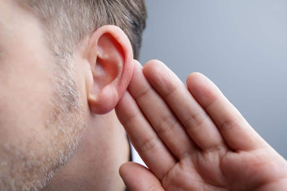 Hombre con la mano en el oído escuchando