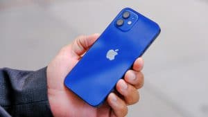 Persona con un iPhone 12 azul marino en la mano izquierda